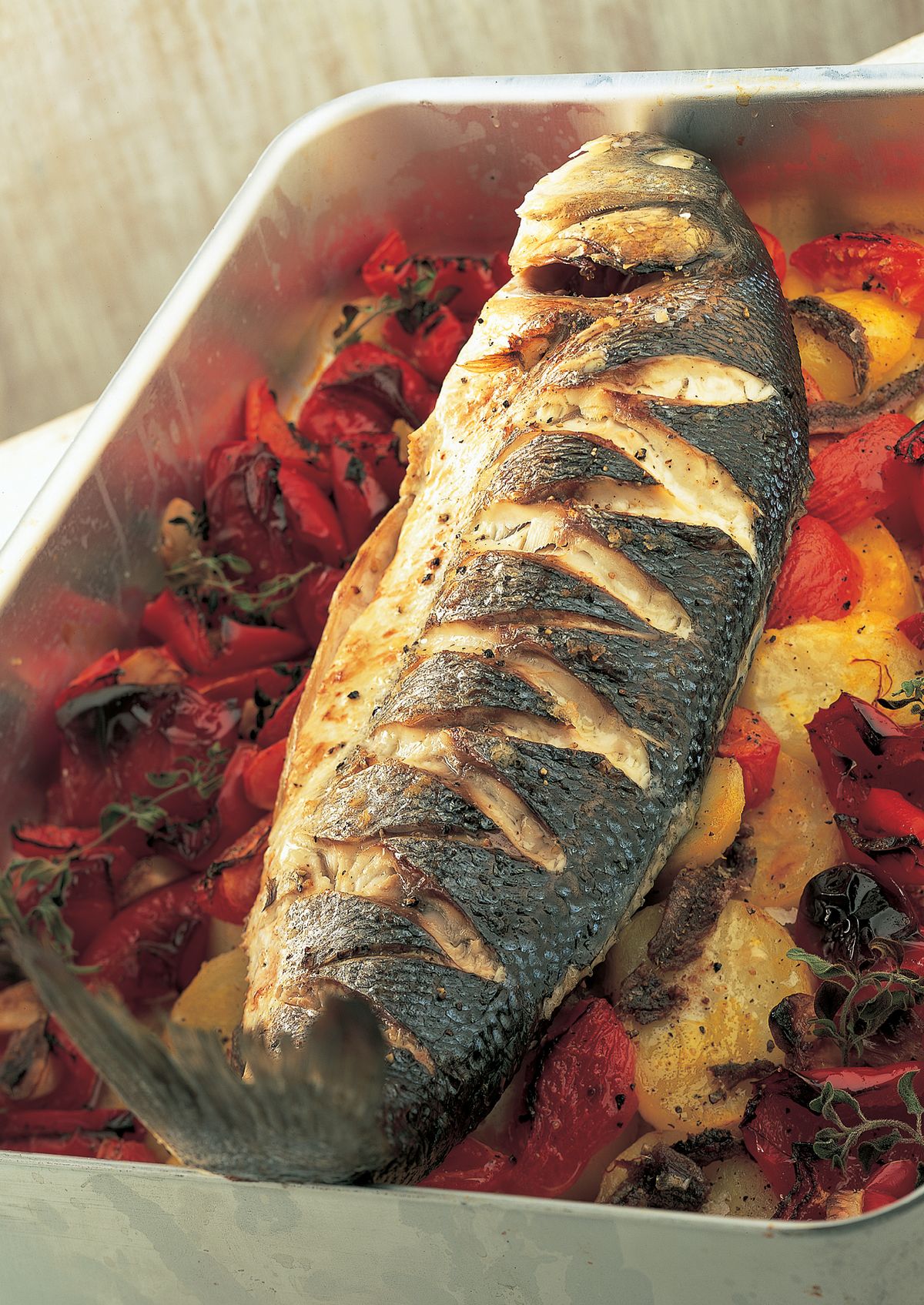 Baked Sea Bass with Roasted Red Peppers, Tomatoes, Anchovies and Potatoes