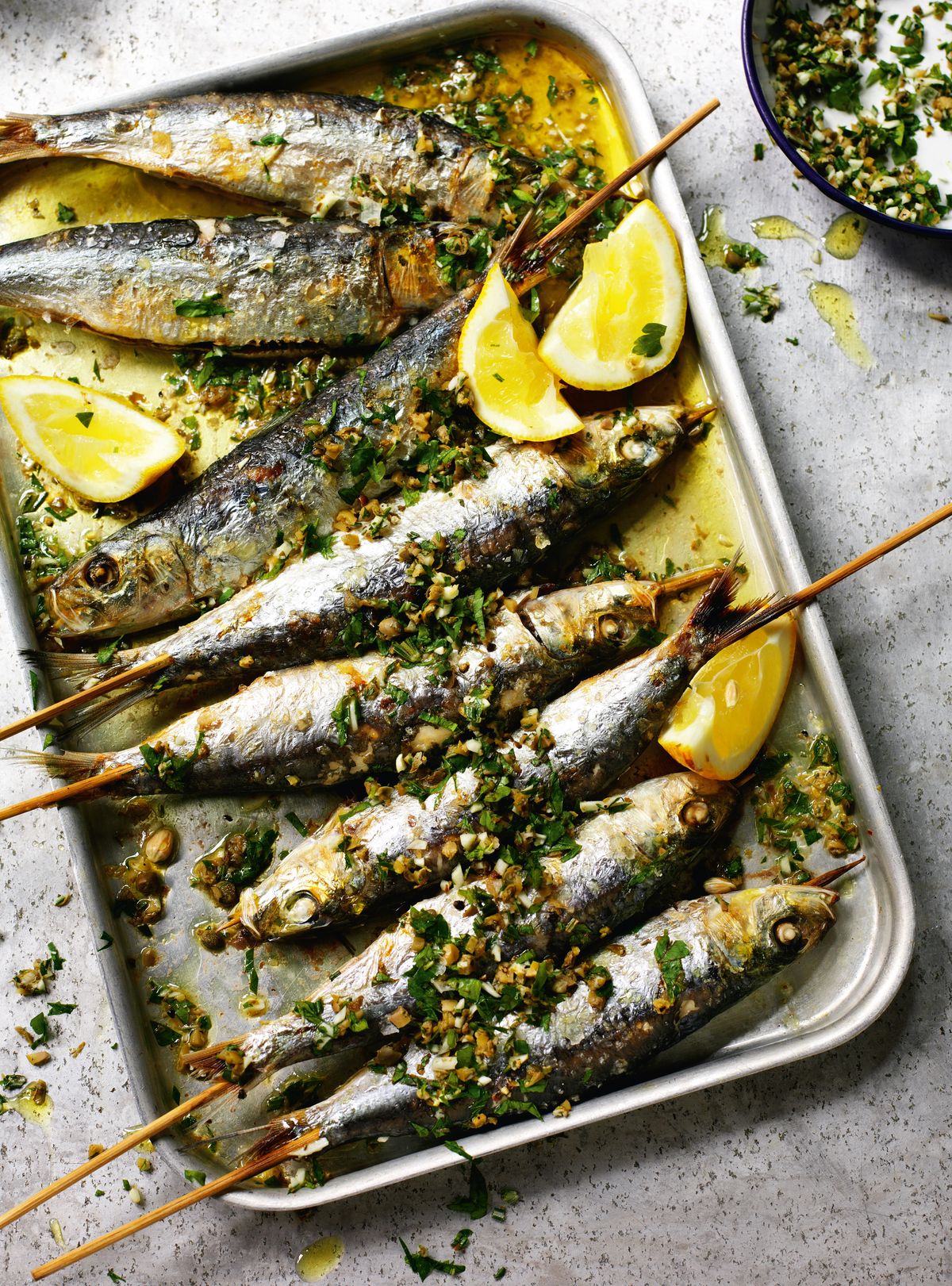 Grilled sardines with coarsely chopped green herbs