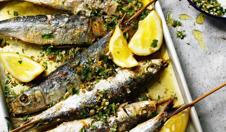 Grilled sardines with coarsely chopped green herbs